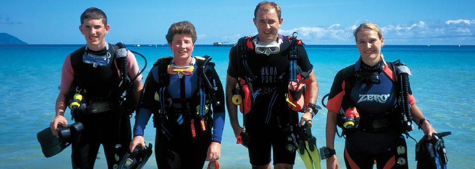 Instructor pointing out marine life to a student underwater.